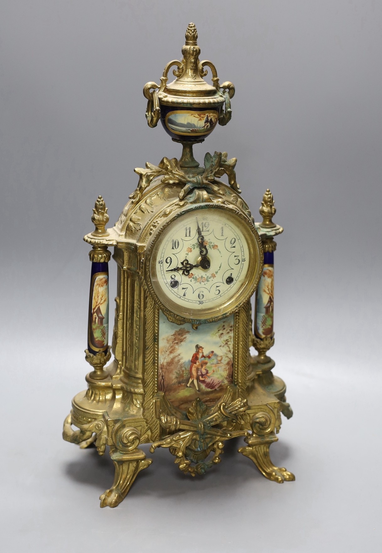 A ornamental gilt French mantel clock with painted porcelain insets - 41.5cm tall